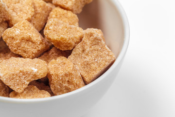 Brown cane sugar cubes isolated on white background