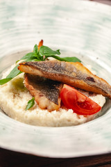 fish grill dish baked whole grilled on a plate with vegetables and lemon