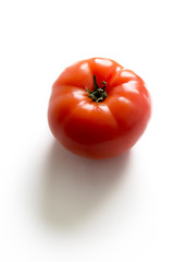 A ripe fresh red tomato isolated on white background, side view