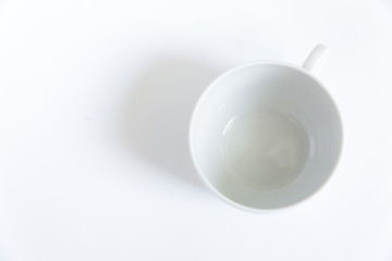 Empty white tea cup on a white background with a shadow. View from above.