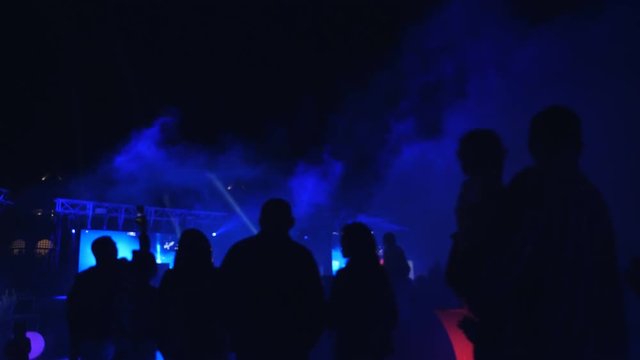 Cinemagraph - green laser rays at a party. Party outdoors. Laser show in a nightclub under the open sky. Psychedelic effect.