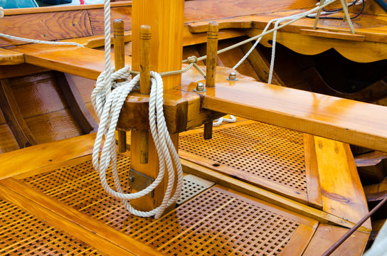 Interior of a small wooden boat with ropes.