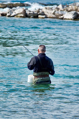 man fishing inside a river in italy