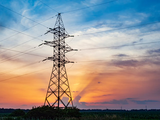 Power lines support at sunset.