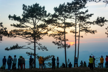 Tourists stand to watch the sun rise at Pha Nok Aen Phu Kradueng on January 12,2019 in Loei,...