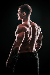 rear view.handsome male bodybuilder .isolated on black