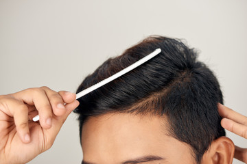Close up photo of clean healthy man's hair. Young man comb his hair - obrazy, fototapety, plakaty