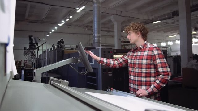 Male student Works on Computer in printing house.