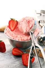 Strawberry ice cream scoop on a rustic white background with fresh strawberries