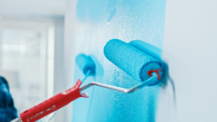 Close-Up Shot of a Wall Being Painted with a Roller. Color of the Paint is Light Blue. Flat...
