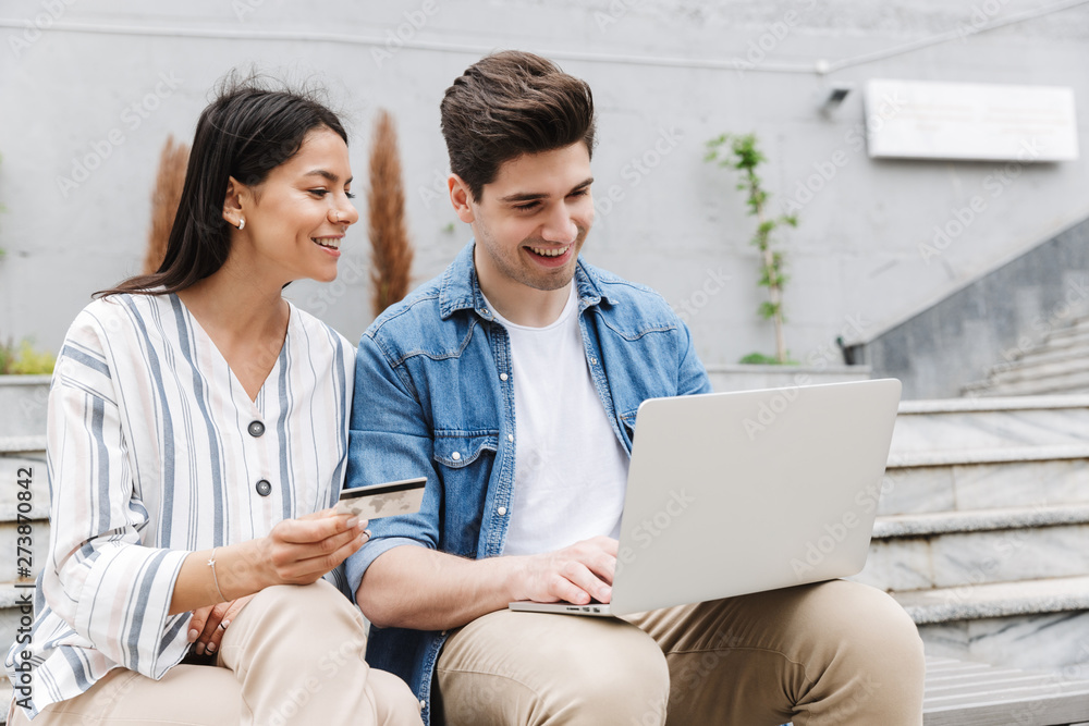 Poster happy young amazing loving couple business people colleagues outdoors outside using laptop computer 