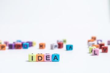 Colorful english alphabet cube with word IDEA on white paper background.