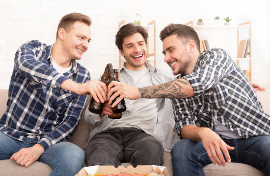 Cheers. Happy Friends Drinking Beer At Home