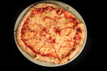 top view of whole sliced cheese pizza on round white plate