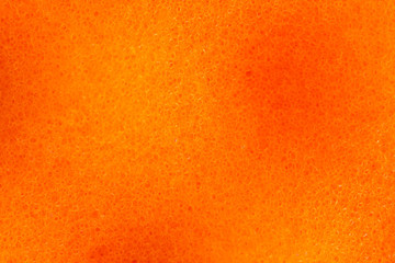 Orange abstract background and porous surface pattern with light and dark patches. Nanostructure and molecular composition of the material sponge for washing dishes. Image under the microscope, macro.