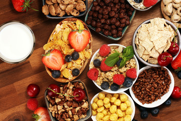 Cereal. Bowls of various cereals, berries and milk for breakfast. Muesli with kids cereals.