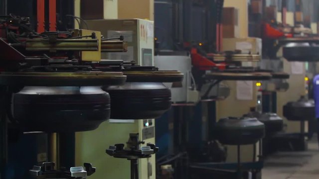 Tire production machine close up. Forming tire machine in action. Robotic machine in a tire factory. Automotive wheel molding in a factory. Modern automated tire forming tires machine.