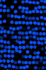Unfocused abstract dark blue bokeh on black background. defocused and blurred many round light