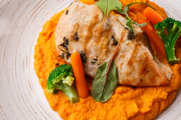 Chicken breast steak with carrot puree baby carrot and broccoli. Grilled chicken slice with baby carrot puree. wooden backgrounf