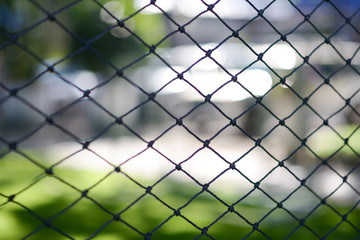 Fototapeta premium Looking through a net.Selective focus on a football net with blur background.Artificial turf with a net.