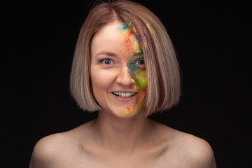 Naklejka premium Studio portrait of young fashion model with bright colorful mix of paint.