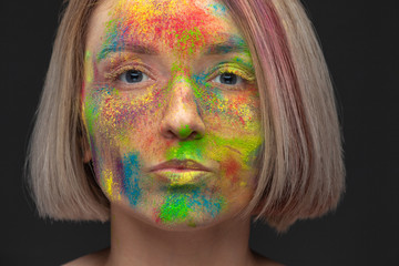Naklejka premium Studio portrait of young fashion model with bright colorful mix of paint.