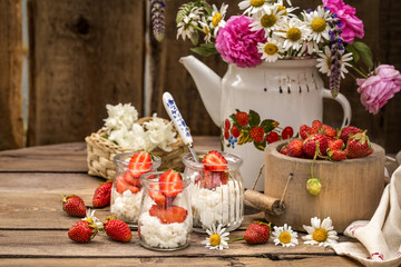 strawberry with cream cheese in glass jars, healthy summer food in a rustic style
