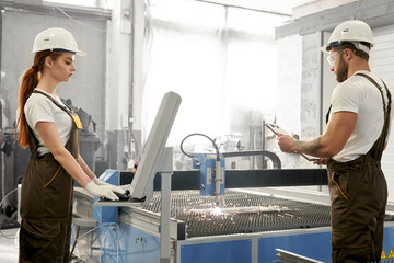 Female worker looking at computer while male keeping folder