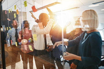 Diverse businesspeople high fiving together after an office brai