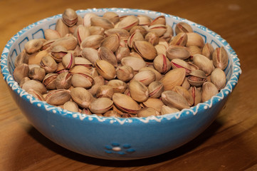 Pistachios in the bowl on the wooden table