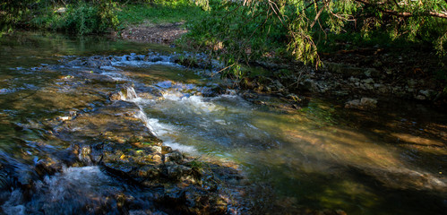 Naklejka na ściany i meble A small waterfall in southwest Missouri makes a tranquil scene on a spring evening.
