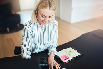 Businesswoman talking with her client on a headset at work