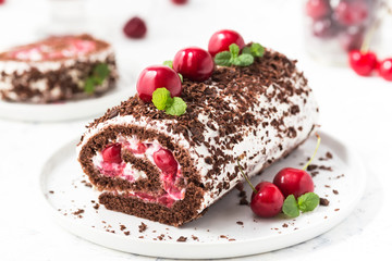 Chocolate roll cake with cream and cherries. Summer dessert  with berries