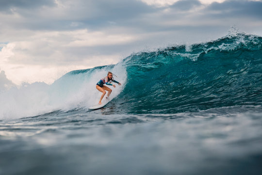 Surf girl on surfboard. Surfer woman and big blue wave - Powered by Adobe