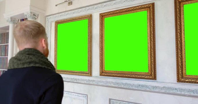 Art gallery worker comparing three pictures