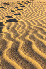 Closeup on the sand dunes. Footprints in the sand.