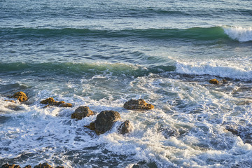Ocean coast with rocks and waves at sunrise. Beautiful seascape