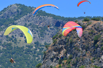 Paragliding. Paragliders on a blue sky and mountains background.