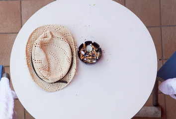 top view of cigarette ends and ash in filthy ashtray on wooden table