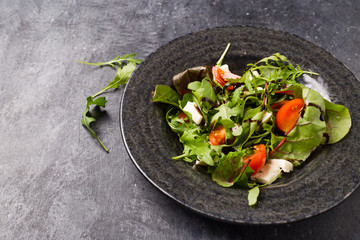 Healthy vegetable salad of fresh tomato, onion, and sesame on plate. Diet menu. Top view.