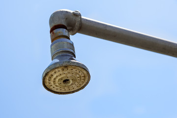 Hard water deposit and rust on shower tap .