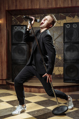 Young artistic man singing with microphone