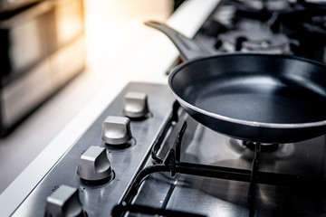 Fototapeta na wymiar Black Teflon pan on modern gas stove in the kitchen. Cookware or kitchenware concepts