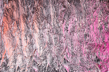 Abstract crumpled foil background. Grunge photo background. Pink and orange shadows