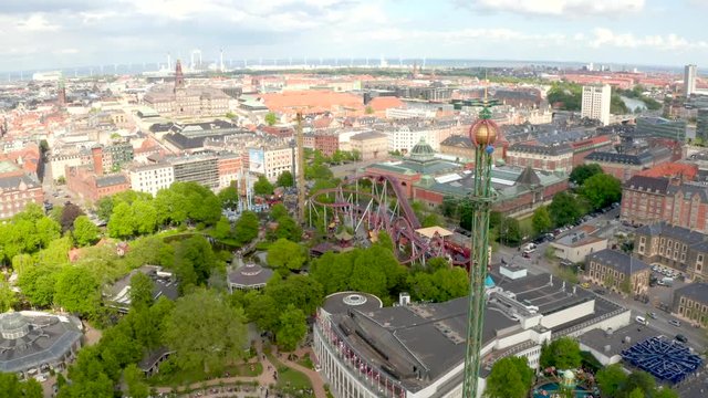 Aerial view of the Tivoli Gardens amusement park with people, visitors, attractions and rides. Urban view of the city of Copenhagen in Denmark, Europe