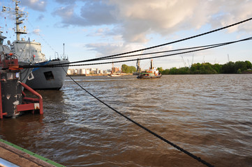 Im Hafen, ein Schiff ist mit Seilen am Kai festgemacht.