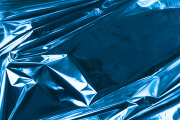 Abstract crumpled foil background. Grunge photo background. Blue colors