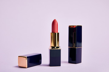 various shiny lipsticks in tubes on purple