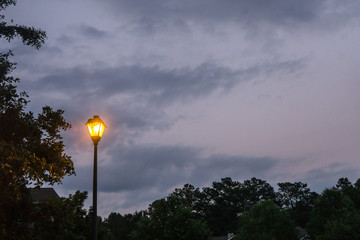 Fototapeta na wymiar Single lone street light lamp post at night shining in the dark in the evening