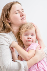 Mother calming her crying baby girl at home